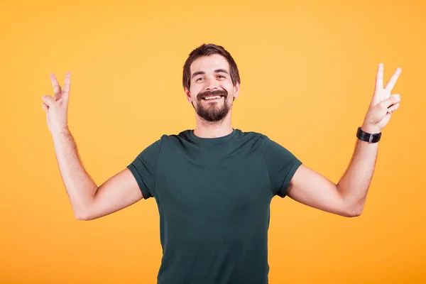 Glücklich lächelnder Mann zeigt Friedenszeichen mit beiden Händen — Stockfoto