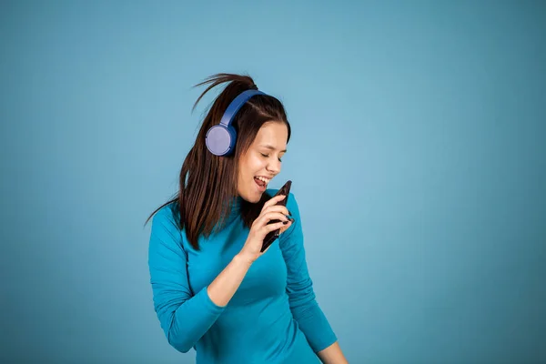 Linda mujer joven cantando en su teléfono mientras baila —  Fotos de Stock