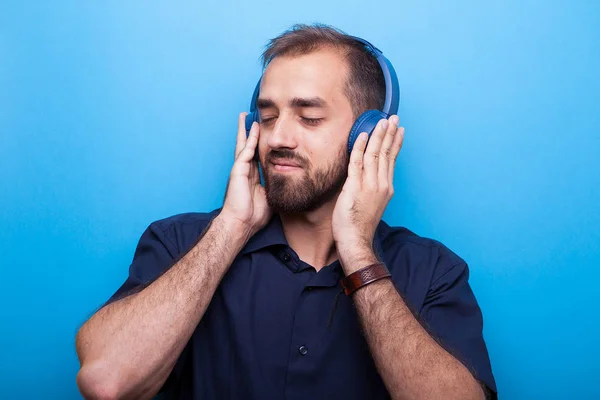 Joven guapo escuchando música a través de auriculares —  Fotos de Stock
