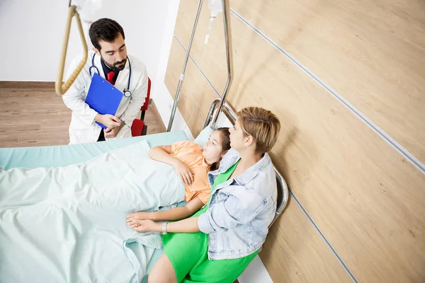 Médico dando la noticia a la niña paciente y madre —  Fotos de Stock