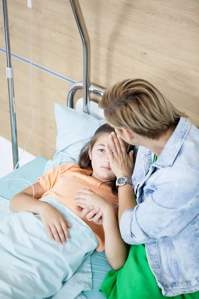 Mãe cuidando de sua filha no quarto do hospital — Fotografia de Stock