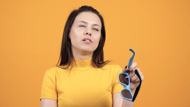 Retrato de mulher jovem mascar chiclete e colocar óculos de sol — Vídeo de Stock