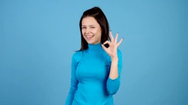 Oldukça sevimli kız kameraya el ve göz kırpmalar ile ok işareti yapar