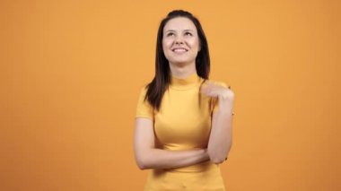 Mutlu endişeli kız canlı turuncu zemin üzerine