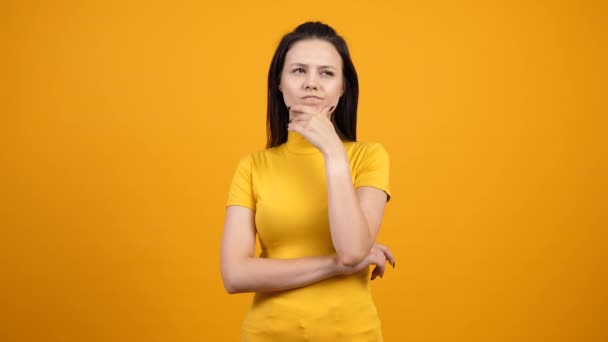 Mujer pensante sobre fondo amarillo — Vídeo de stock