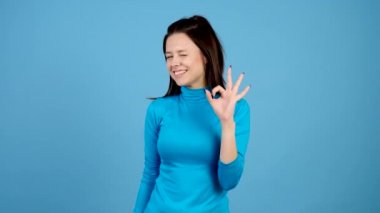 Sürpriz kız kameraya winks, ok işareti yapar sonra başparmak ortaya