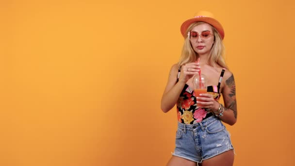 Сексуальная загорелая женщина в солнечных очках пьет тропический напиток — стоковое видео
