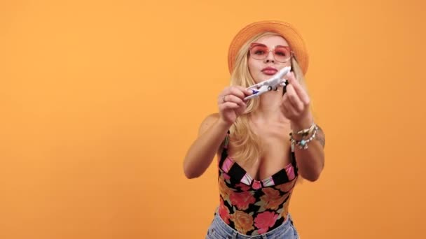 Sexy tätowierte Frau spielt mit einem Spielzeugflugzeug — Stockvideo
