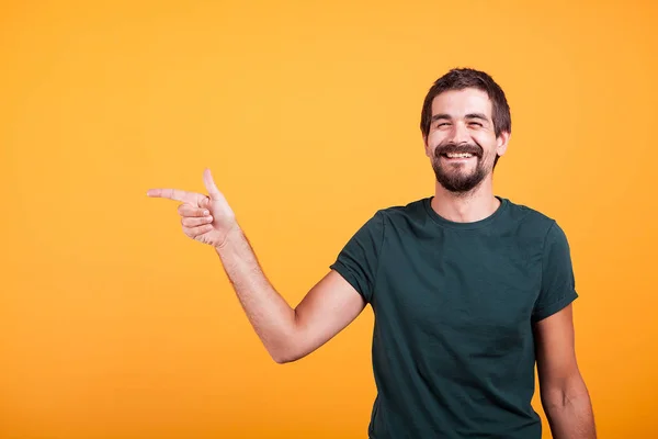 Fröhlich lächelnder Mann zeigt rechts auf Copyspace — Stockfoto
