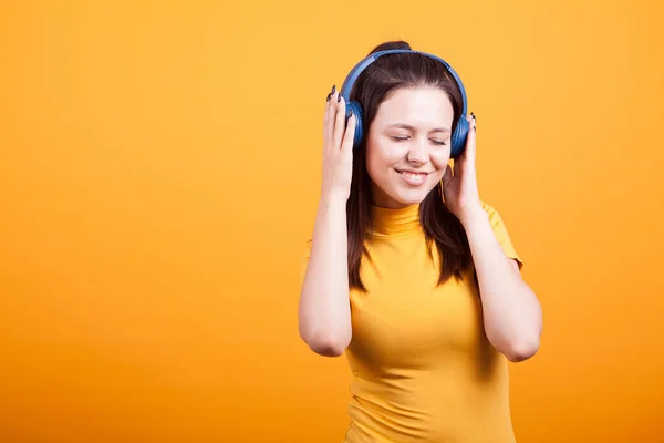 Bonito jovem mulher ouvindo música no estúdio — Fotografia de Stock