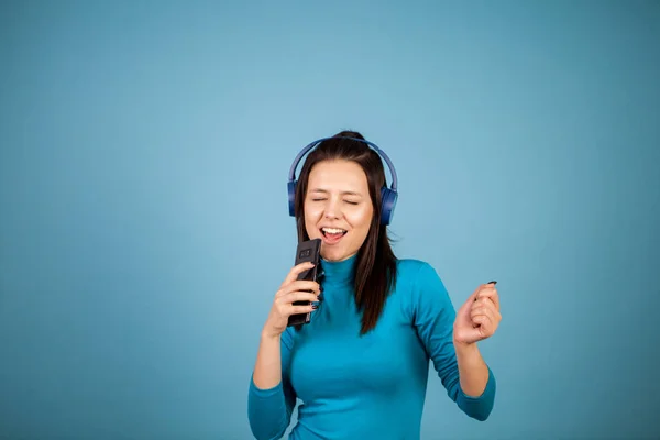 Bonito jovem mulher cantando em seu telefone enquanto dança — Fotografia de Stock