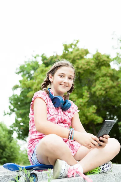 Dziewczyna zabawy z jej telefon w parku — Zdjęcie stockowe