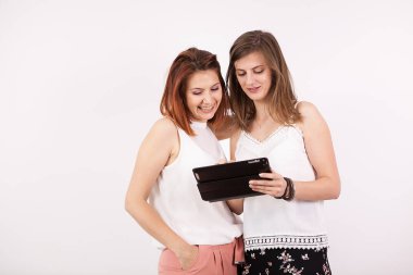 İki kız gülümseyerek ve bir tablet Pc vasıl arıyorum arkadaşlar