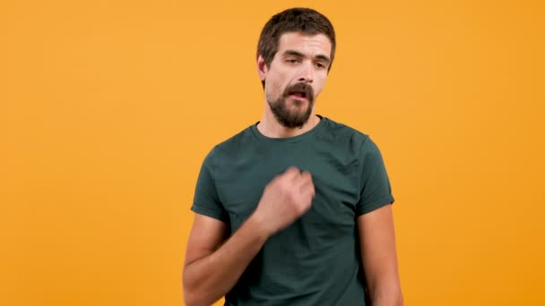 Hombre aburrido con una camiseta verde casual y goma de mascar — Vídeos de Stock