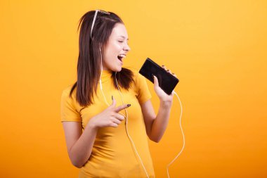 Ona telefon şarkı ve işaret eden sevimli genç kadın