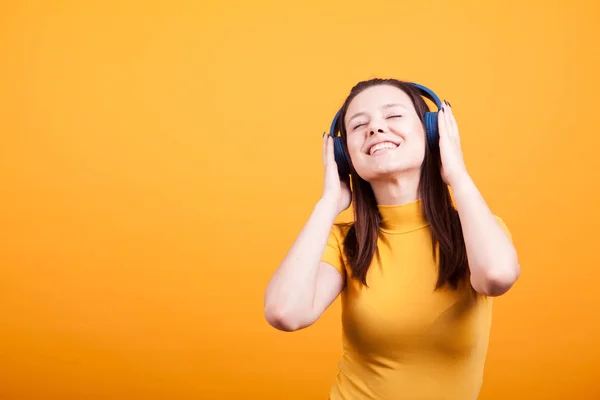 Bonito jovem mulher ouvindo música no estúdio — Fotografia de Stock