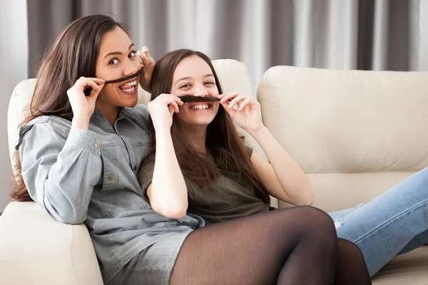 Two sisters playing with mustache hair — Stock Photo, Image