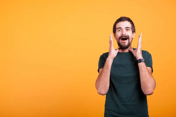 Schockierter Mann mit den Händen im Gesicht, der in die Kamera blickt — Stockfoto