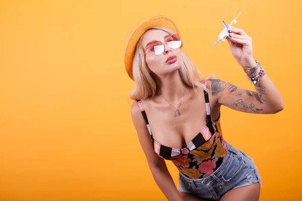 Genç kadın rahat kıyafetler oyuncak uçak ile oynarken — Stok fotoğraf