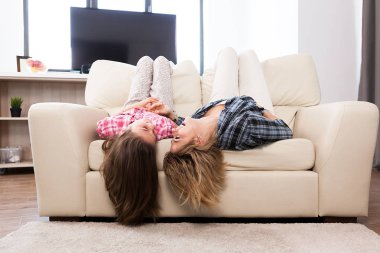 Sevimli kızıyla kanepede kafalarını ile baş aşağı yalan birlikte güzel annem