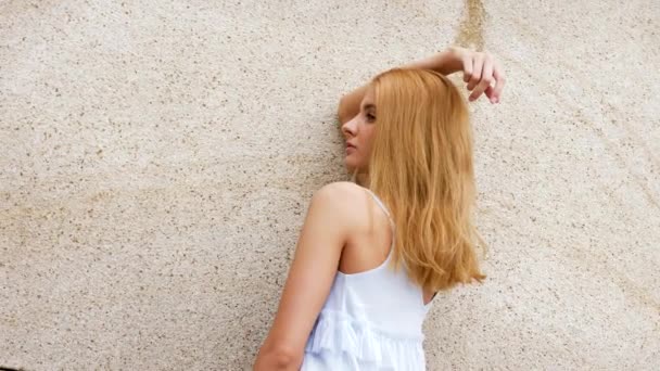 Glamour-Frau im blauen Sommerkleid vor einer Wand posiert für die Kamera — Stockvideo