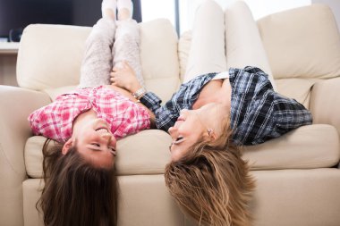 Sevimli kızıyla kanepede kafalarını ile baş aşağı yalan birlikte güzel annem