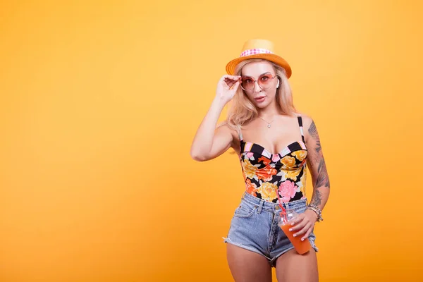 Aantrekkelijke Jonge Vrouw Drinken Sinaasappelsap Gele Achtergrond Met Zonnebril Studio — Stockfoto