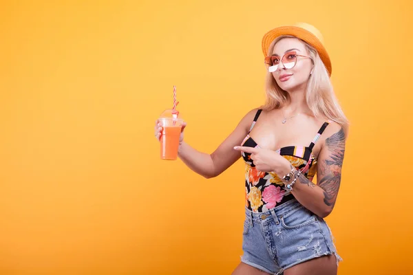 Feliz jovem mulher olhando para o verão fresco suco de laranja pensando ela é sexy — Fotografia de Stock