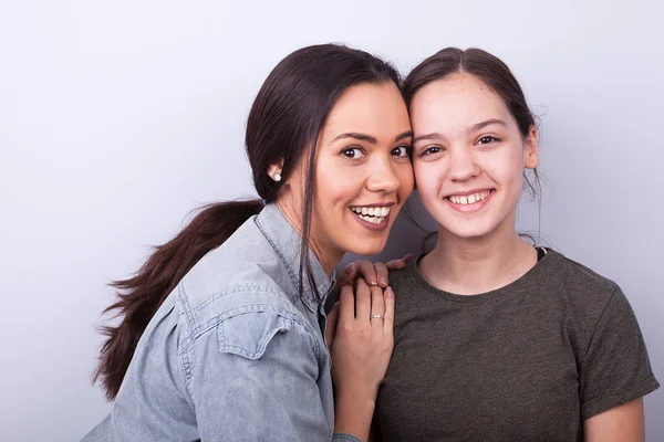 Gri arka plan üzerinde iki mutlu kız kardeş — Stok fotoğraf