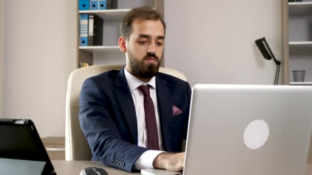 Multitasking v kanceláři. Mladý podnikatel pracují na přenosném počítači — Stock video