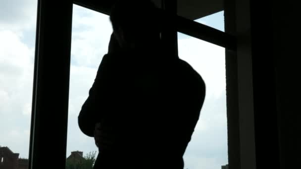 Уставший, измученный и напряженный бизнес-силуэт подходит к окнам — стоковое видео