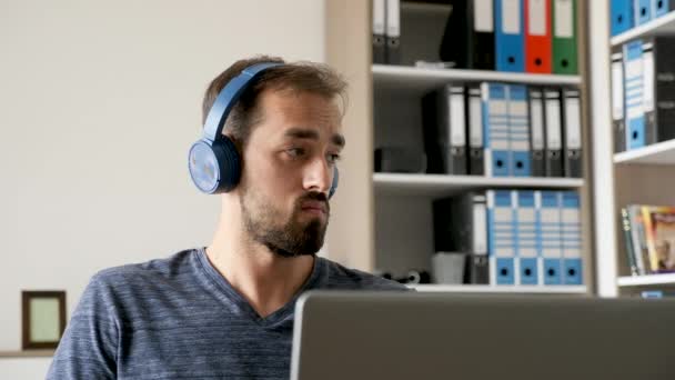 Portret van digitale artiest luisteren naar muziek en werkt op zijn computer — Stockvideo
