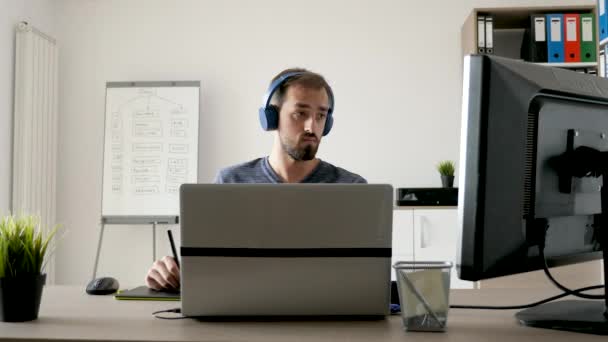 Kunstenaar op zijn Bureau die werken met een digitaal tablet — Stockvideo