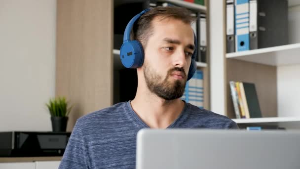 Creatieve bebaarde man luistert naar muziek terwijl u werkt — Stockvideo