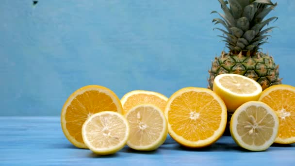 Limones y naranjas en rodajas junto a una piña — Vídeos de Stock