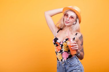 Muhteşem sarışın saçlı kadın güneş gözlüğü ile taze portakal suyu gösterilen