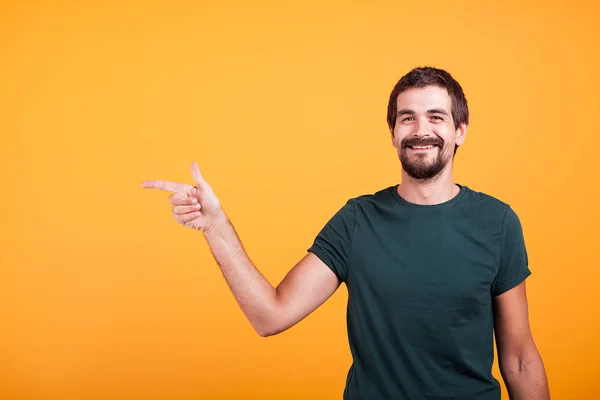 Homme souriant joyeux pointant vers sa droite à l'espace de copie — Photo