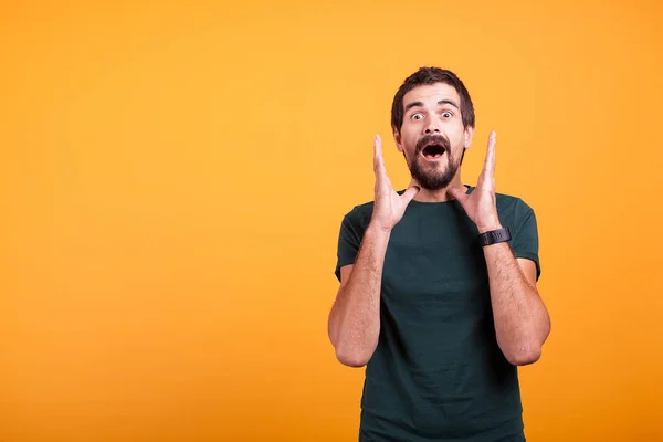 Schockierter Mann mit den Händen im Gesicht, der in die Kamera blickt — Stockfoto