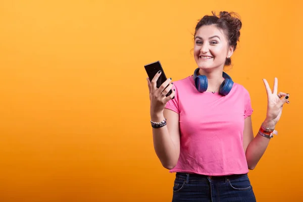 Vacker ung kvinna som ler på sin telefon — Stockfoto