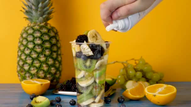 Topping van een gezonde en lekkere fruitsalade met slagroom — Stockvideo