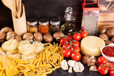 Ahşap arka plan üzerinde makarna, makarna ve ham pişmemiş makarna