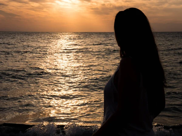 Tânără femeie frumoasă admirând apusul soarelui la mare — Fotografie, imagine de stoc