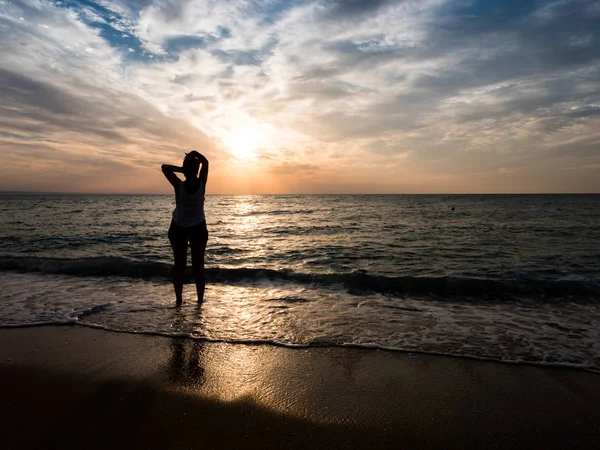 Giovane donna verso il bel tramonto sulla spiaggia del mare . — Foto Stock