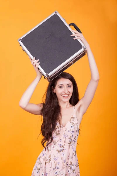 Krásná mladá žena drží aktovku ve studiu nad žlutým pozadím — Stock fotografie