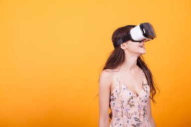 Mutlu kız VR kulaklık gözlük Sanal gerçekliğin sarı arka plan üzerinde Studio'yu kullanarak deneyim elde