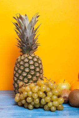 Ananas, üzüm ve diğer meyve sarı zemin üzerine