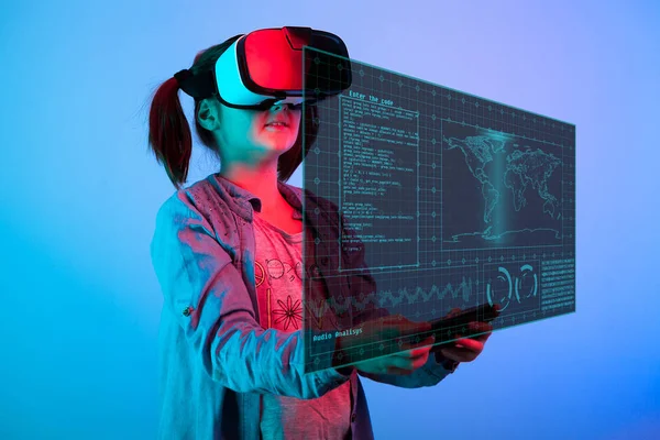 Chica joven con un auricular VR en la cabeza mirando una pantalla futurista en fron de su — Foto de Stock