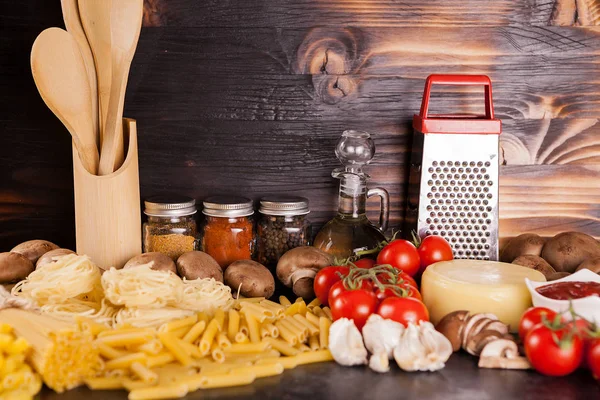 Ahşap arka plan üzerinde makarna, makarna ve ham pişmemiş makarna