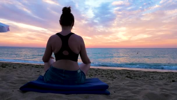 Woman practicing yoga at the sunrise on the beach — Stock Video