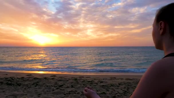 Žena relaxaci na pláži tím, že cvičí jógu — Stock video